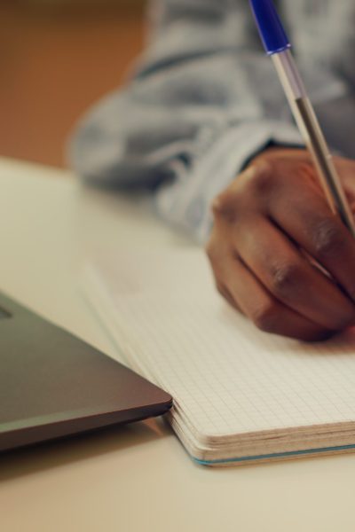 Woman taking handwritten ideas notes Woman taking handwritten ideas notes at home desk, trying to find perfect work flow and develop online freelancing career. Person using notebook planning for job productivity. Close up.